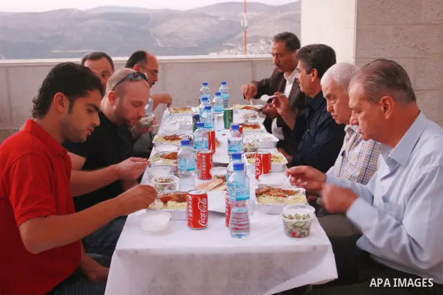 Palestinians take part in the Central Ramadan breakfast for the first orphanage, organized by the United Arab Emirates State charity , in the West Bank city of Nablus, monday Aug . 22,2011. Muslims throughout the world a...