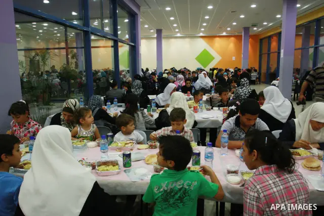 Palestinians take part in the Central Ramadan breakfast for the first orphanage, organized by the United Arab Emirates State charity , in the West Bank city of Nablus, monday Aug . 22,2011. Muslims throughout the world a...