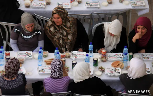 Palestinians take part in the Central Ramadan breakfast for the first orphanage, organized by the United Arab Emirates State charity , in the West Bank city of Nablus, monday Aug . 22,2011. Muslims throughout the world a...