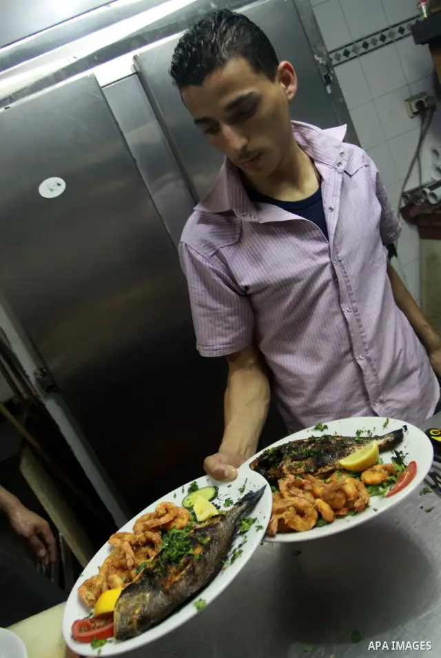 In this photo taken on May 5, 2011: A Palestinian assistant Chef prepares seafood at the Moneer abu Hassira restaurant in Gaza city, ordinary people and politicians alike are served top-class seafood at the Moneer abu Ha...