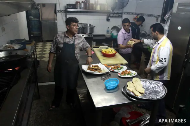 In this photo taken on May 5, 2011: A Palestinian Chef and his assistant prepare seafood at the Moneer abu Hassira restaurant in Gaza city, ordinary people and politicians alike are served top-class seafood at the Moneer...