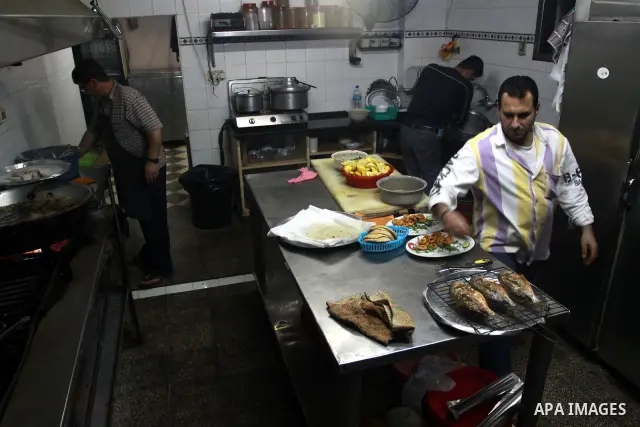 In this photo taken on May 5, 2011: A Palestinian Chef and his assistant prepare seafood at the Moneer abu Hassira restaurant in Gaza city, ordinary people and politicians alike are served top-class seafood at the Moneer...