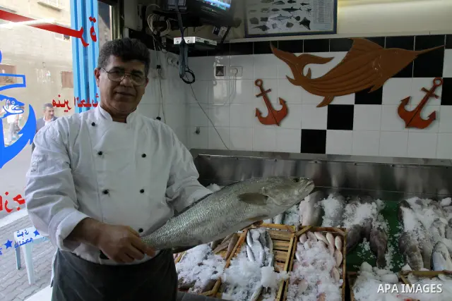 In this photo taken on May 5, 2011: A Palestinian Chef displays fish at the Moneer abu Hassira restaurant in Gaza city, ordinary people and politicians alike are served top-class seafood at the Moneer abu Hassira restaur...