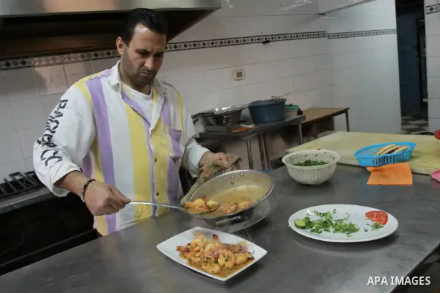 In this photo taken on May 5, 2011: A Palestinian assistant Chef prepares seafood at the Moneer abu Hassira restaurant in Gaza city, ordinary people and politicians alike are served top-class seafood at the Moneer abu Ha...