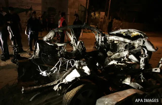 Palestinians look at the wreckage of a car after it was hit by an Israeli missile, killing an Islamic Jihad militant in Rafah, southern Gaza Strip, early Wednesday, Aug. 24, 2011. The Israeli military said the gunman had...