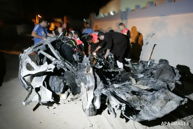Palestinians look at the wreckage of a car after it was hit by an Israeli missile, killing an Islamic Jihad militant in Rafah, southern Gaza Strip, early Wednesday, Aug. 24, 2011. The Israeli military said the gunman had...
