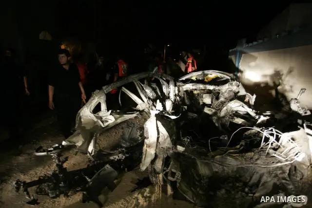Palestinians look at the wreckage of a car after it was hit by an Israeli missile, killing an Islamic Jihad militant in Rafah, southern Gaza Strip, early Wednesday, Aug. 24, 2011. The Israeli military said the gunman had...