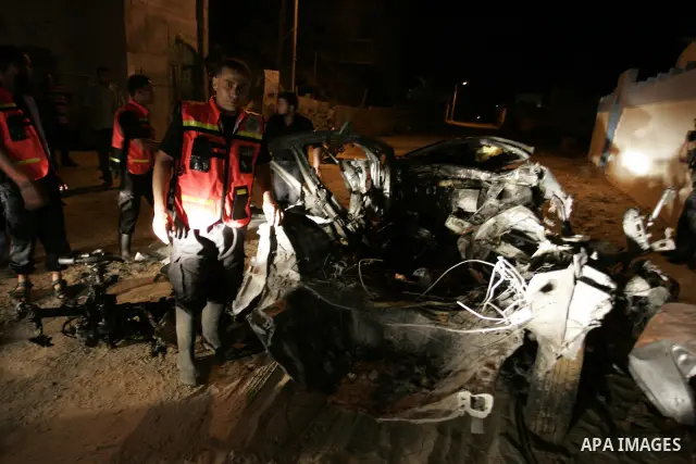 Palestinians look at the wreckage of a car after it was hit by an Israeli missile, killing an Islamic Jihad militant in Rafah, southern Gaza Strip, early Wednesday, Aug. 24, 2011. The Israeli military said the gunman had...