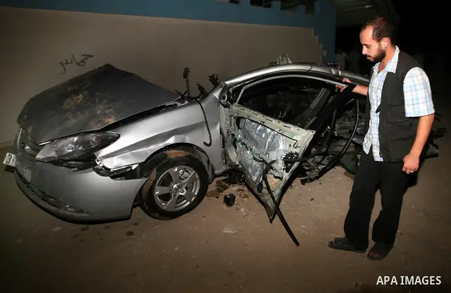 Palestinians check the damage to a car after an Israeli air strike in Rafah in the southern Gaza Strip, on August 24, 2011. Ismael Al-Asmar, one of the militant leaders of the group Islamic Jihad , was killed in the air...