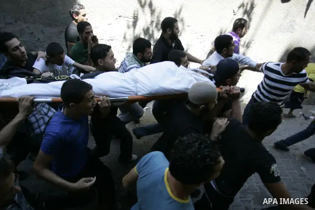 Palestinian mourners carry the body of Islamic Jihad militant Ismael Al-Asmar during his funeral after an Israeli air strike hit his car in Rafah in the southern Gaza Strip on 24 August 2011. Al-Asmar, one of the militan...