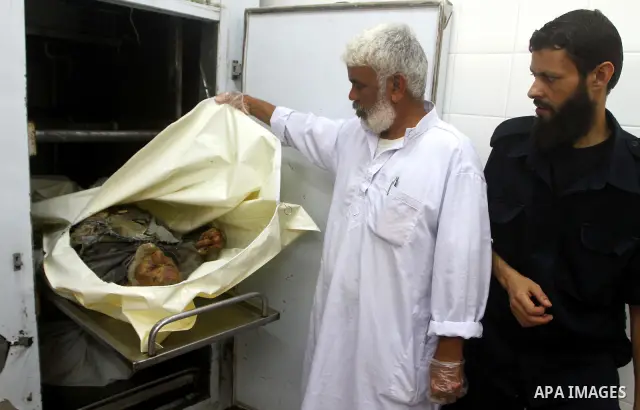 Palestinians gather around the body of Ismail Amum ,65, at Al-Aqsa hospital morgue in the central Gaza Strip on August 24,2011. Israeli air strikes killed a local commander of the Islamic Jihad militant group in the Gaza...