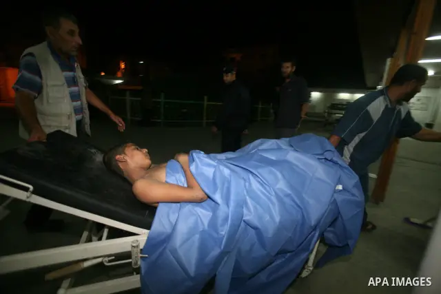 Palestinians carry a wounded boy into Shuhada El- Aqsa hospital following Israeli shell in Gaza, Aug. 25, 2011. Photo by Ali Jadallah