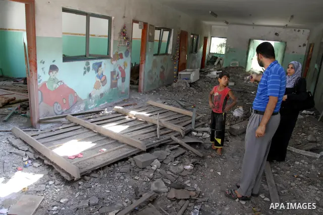Palestinians inspect the damage in the kindergarten that was destroyed by an overnight Israeli air raid in Beit Lahia, on August 25, 2011. A series of Israeli air strikes on Gaza over the past 24 hours have killed five P...