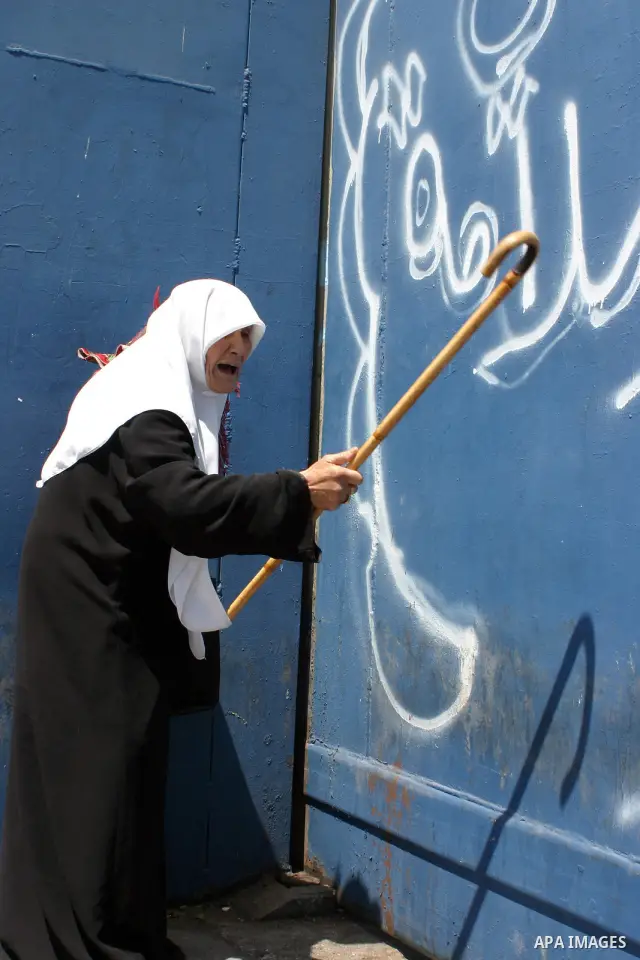 Palestinian women wait to pass the checkpoint on their way to pray at the Al Aqsa Mosque, on the last Friday of the Muslim holy month of Ramadan, in the West Bank town of Bethlehem, early Friday, Aug. 26, 2011. Muslims a...