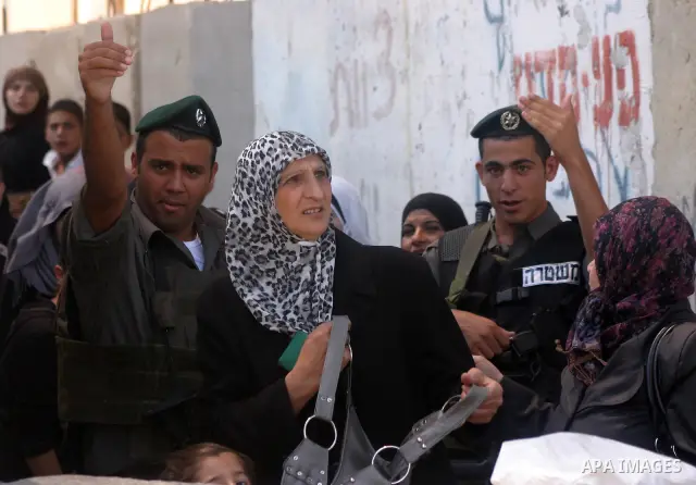 Palestinian women wait to pass the checkpoint on their way to pray at the Al Aqsa Mosque, on the last Friday of the Muslim holy month of Ramadan, in the West Bank town of Bethlehem, early Friday, Aug. 26, 2011. Muslims a...