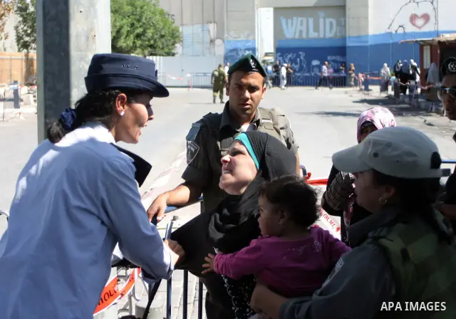 Palestinian women wait to pass the checkpoint on their way to pray at the Al Aqsa Mosque, on the last Friday of the Muslim holy month of Ramadan, in the West Bank town of Bethlehem, early Friday, Aug. 26, 2011. Muslims a...