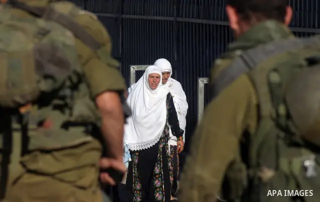 Palestinian women wait to pass the checkpoint on their way to pray at the Al Aqsa Mosque, on the last Friday of the Muslim holy month of Ramadan, in the West Bank town of Bethlehem, early Friday, Aug. 26, 2011. Muslims a...