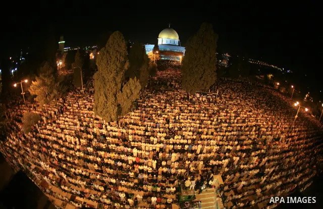 Palestinian muslim worshippers pray outside the Dome of the Rock in the Al-Aqsa Mosque compound in Jerusalem's Old City during the Islamic anniversary Lailat al-Qader, also known as the Night of Power, on August 27, 2011...