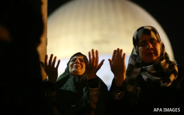 A Palestinian Muslim woman prays outside the Dome of the Rock in the Al-Aqsa Mosque compound in Jerusalem's Old City during the Islamic anniversary Lailat al-Qader, also known as the Night of Power, on August 27, 2011. P...