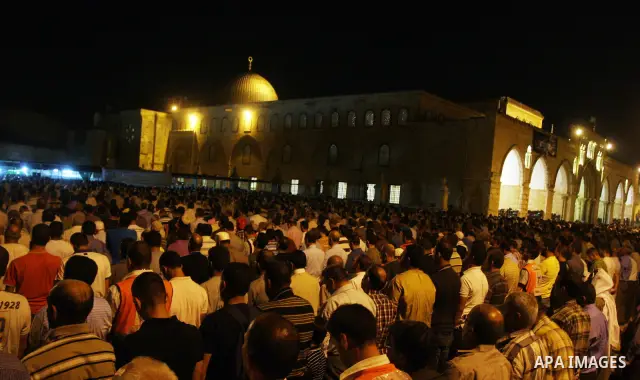 Palestinian muslim worshippers pray outside the Dome of the Rock in the Al-Aqsa Mosque compound in Jerusalem's Old City during the Islamic anniversary Lailat al-Qader, also known as the Night of Power, on August 27, 2011...