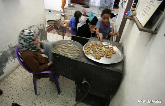Palestinians prepare date-filled mini cakes traditional for the Eid al-Fitr, a three-day holiday that marks the end of the fasting month of Ramadan,In their home in Rafah, southern Gaza Strip on Aug. 28, 2011. Photo by A...