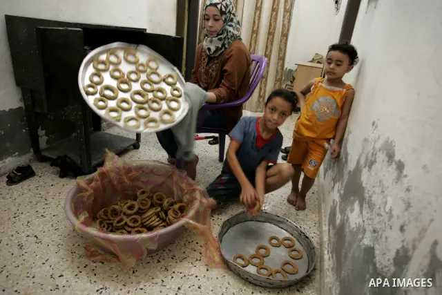 Palestinians prepare date-filled mini cakes traditional for the Eid al-Fitr, a three-day holiday that marks the end of the fasting month of Ramadan,In their home in Rafah, southern Gaza Strip on Aug. 28, 2011. Photo by A...