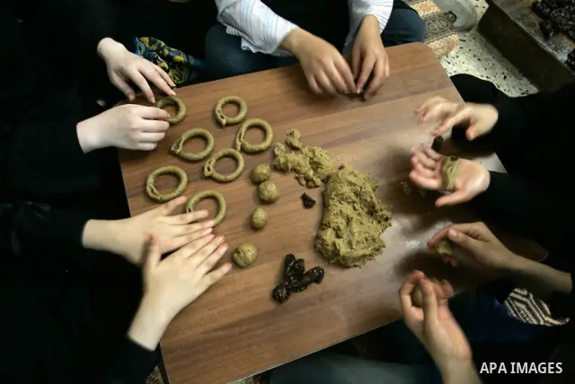 Palestinian women prepare date-filled mini cakes traditional for the Eid al-Fitr, a three-day holiday that marks the end of the fasting month of Ramadan,In their home in Rafah, southern Gaza Strip on Aug. 28, 2011. Photo...