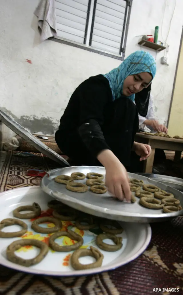 A Palestinian woman prepares date-filled mini cakes traditional for the Eid al-Fitr, a three-day holiday that marks the end of the fasting month of Ramadan,In their home in Rafah, southern Gaza Strip on Aug. 28, 2011. Ph...