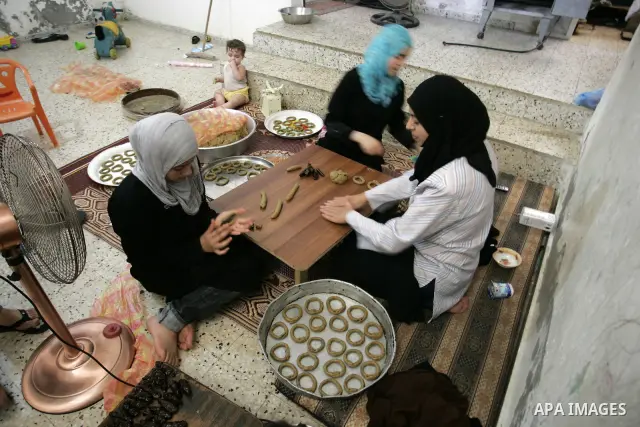 Palestinian women prepare date-filled mini cakes traditional for the Eid al-Fitr, a three-day holiday that marks the end of the fasting month of Ramadan,In their home in Rafah, southern Gaza Strip on Aug. 28, 2011. Photo...