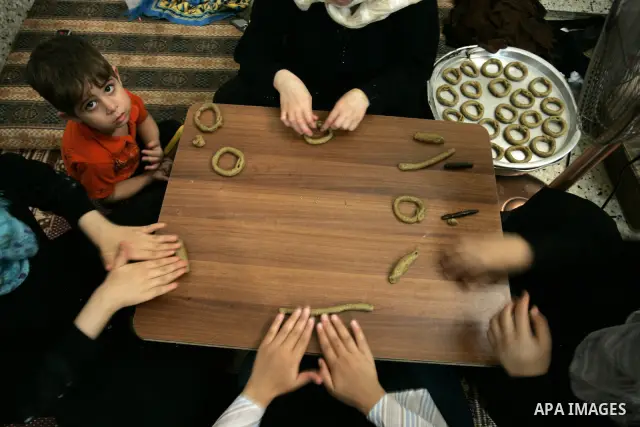 Palestinian women prepare date-filled mini cakes traditional for the Eid al-Fitr, a three-day holiday that marks the end of the fasting month of Ramadan,In their home in Rafah, southern Gaza Strip on Aug. 28, 2011. Photo...