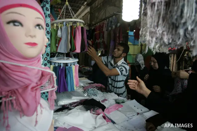 Palestinian women shop at a clothes shop as Muslims shop ahead of the Eid al-Fitr celebrations in Rafah, southern Gaza Strip on Aug. 28, 2011. Muslims in the region will celebrate the Eid al-Fitr holiday starting with th...
