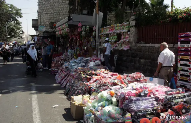 Palestinian vendors display their goods for sale during preparations for Eid aL-Fitr at the main market, in Jerusalem's old city 28 August 2011. Muslims throughout the world buy clothes and other popular items to prepare...