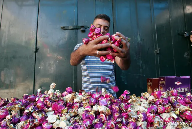 A Palestinian vendor displays his goods for sale during preparations for Eid aL-Fitr at the main market, in Jerusalem's old city 28 August 2011. Muslims throughout the world buy clothes and other popular items to prepare...