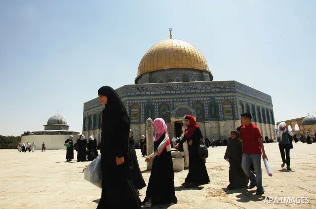 Palestinian Muslims walk past the Dome of the Rock in the al-Aqsa mosque compound in Jerusalem's old city 28 August 2011. Muslims throughout the world buy clothes and other popular items to prepare for The Eid aL-Fitr ,t...