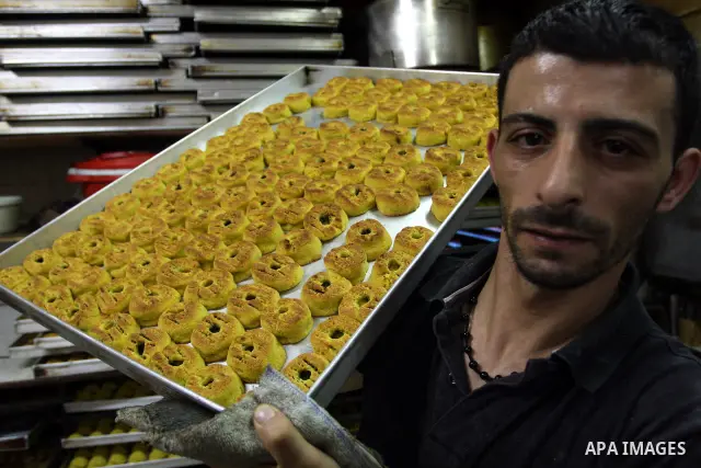 A Palestinian vendor prepares date-filled mini cakes traditional for the Eid al-Fitr, at his shop in the Old City in Jerusalem on Aug. 29, 2011. as Muslims the world over prepare to celebrate Eid al-Fitr, starting with t...