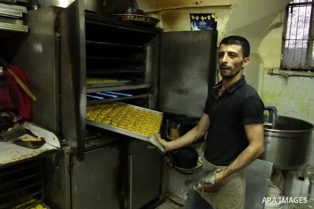 A Palestinian vendor prepares date-filled mini cakes traditional for the Eid al-Fitr, at his shop in the Old City in Jerusalem on Aug. 29, 2011. as Muslims the world over prepare to celebrate Eid al-Fitr, starting with t...