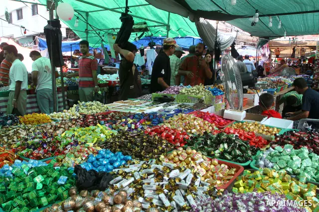 Palestinian vendors display their goods for sale during preparations for Eid aL-Fitr at the main market, in Gaza city 29 August 2011. Muslims throughout the world buy clothes, sweets and other popular items to prepare fo...