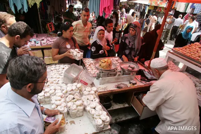 Palestinian vendors display their goods for sale during preparations for Eid aL-Fitr at the main market, in Jerusalem's old city 29 August 2011. Muslims throughout the world buy clothes, sweets and other popular items to...