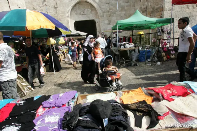 Palestinian vendors display their goods for sale during preparations for Eid aL-Fitr at the main market, in Jerusalem's old city 29 August 2011. Muslims throughout the world buy clothes, sweets and other popular items to...