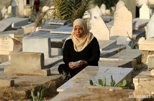 A Palestinians woman visits her relatives' graves in a cemetery during the first day of Eid al-Fitr in Gaza city on August 30, 2011. Eid al-Fitr marks the end of the Muslim holy month of Ramadan. Photo by Mohammed Asad