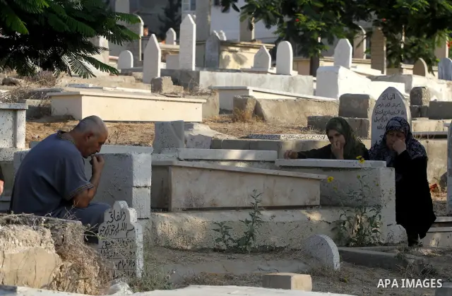 Palestinians visit their relatives' graves in a cemetery during the first day of Eid al-Fitr in Gaza city on August 30, 2011. Eid al-Fitr marks the end of the Muslim holy month of Ramadan. Photo by Mohammed Asad