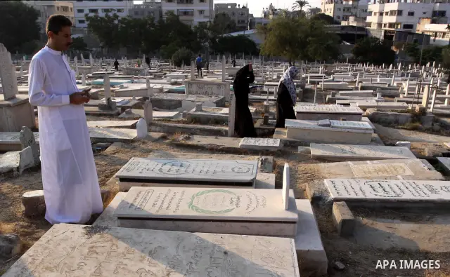 Palestinians visit their relatives' graves in a cemetery during the first day of Eid al-Fitr in Gaza city on August 30, 2011. Eid al-Fitr marks the end of the Muslim holy month of Ramadan. Photo by Mohammed Asad