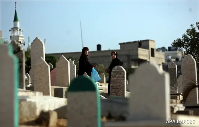 Palestinians visit their relatives' graves in a cemetery during the first day of Eid al-Fitr in the southern Gaza Strip on August 30, 2011. Eid al-Fitr marks the end of the Muslim holy month of Ramadan. Photo by Ali Jada...