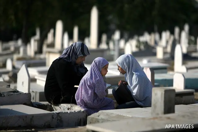 Palestinians visit their relatives' graves in a cemetery during the first day of Eid al-Fitr in the southern Gaza Strip on August 30, 2011. Eid al-Fitr marks the end of the Muslim holy month of Ramadan. Photo by Ali Jada...