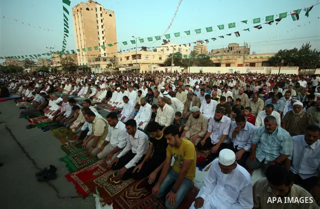 Palestinians attend an open air morning prayer to celebrate Eid al-Fitr in Khan Yunis town the southern Gaza Strip on August 30, 2011. The Palestinian Territories, along with other neighboring and Gulf states, announced...