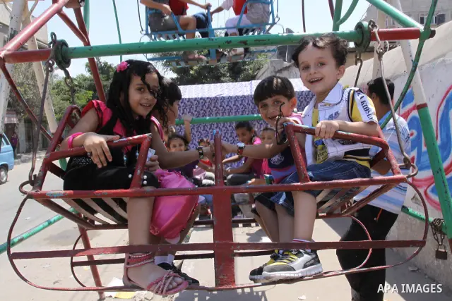 Palestinian children enjoy a ride at an amusement park on the second day of the Eid al-Fitr holiday, which marks the end of the holy fasting month of Ramadan in Gaza City, on August 31 2011. Photo by Mohammed Asad