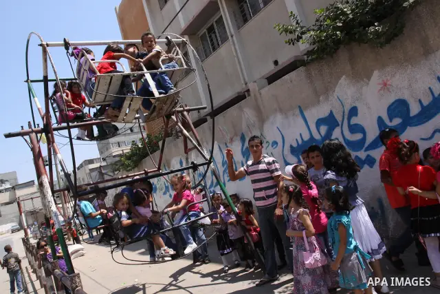 Palestinian children enjoy a ride at an amusement park on the second day of the Eid al-Fitr holiday, which marks the end of the holy fasting month of Ramadan in Gaza City, on August 31 2011. Photo by Mohammed Asad