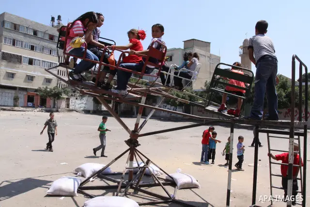 Palestinian children enjoy a ride at an amusement park on the second day of the Eid al-Fitr holiday, which marks the end of the holy fasting month of Ramadan in Gaza City, on August 31 2011. Photo by Mohammed Asad