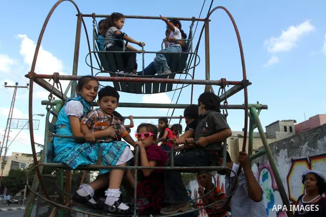 Palestinian children enjoy a ride at an amusement park on the second day of the Eid al-Fitr holiday, which marks the end of the holy fasting month of Ramadan in Gaza City, on August 31 2011. Photo by Ashraf Amra