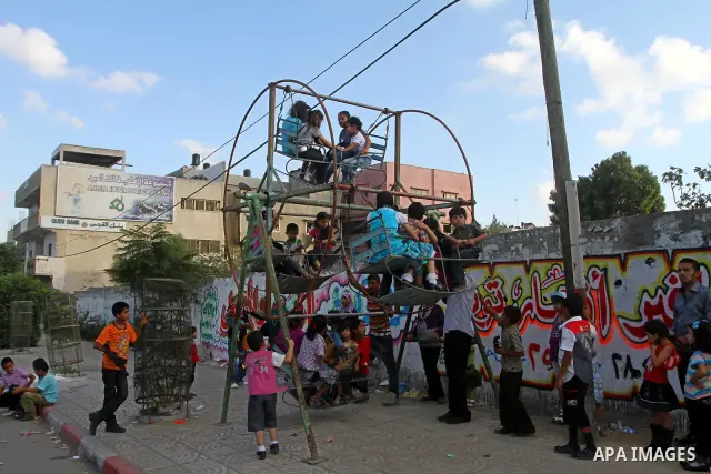 Palestinian children enjoy a ride at an amusement park on the second day of the Eid al-Fitr holiday, which marks the end of the holy fasting month of Ramadan in Gaza City, on August 31 2011. Photo by Ashraf Amra